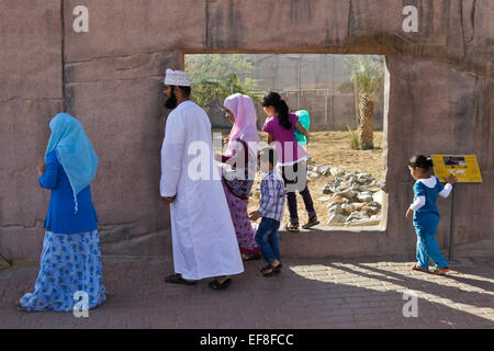 Arabische Familie im Lion ausstellen, Zoo von Al Ain, Abu Dhabi, Vereinigte Arabische Emirate Stockfoto