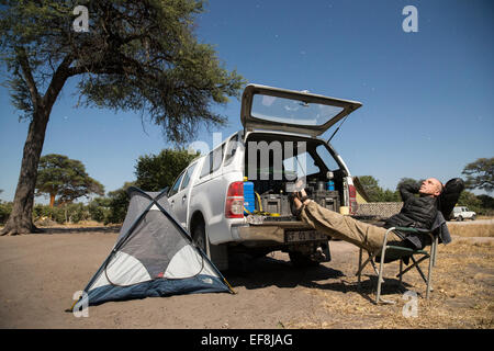 Selbstporträt des Fotografen Paul Souders, Chobe Nationalpark, Botswana, Afrika in Campingplatz unter Licht des Vollmondes ich ruhen Stockfoto