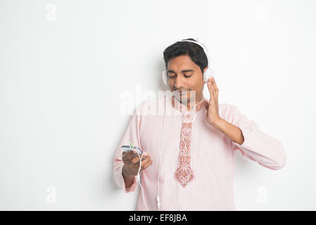 Traditionelle Young Indian Asian männlich College Student Musik hören mit Kopfhörern Stockfoto