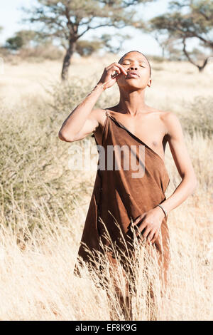Einem jungen Buschmann verwendet ein seidiges Stück Gras als Zahnstocher, Kalahari, Südliches Namibia, Afrika Stockfoto