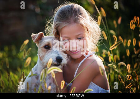 Porträt von Mädchen (6-7) umarmen Hund Stockfoto