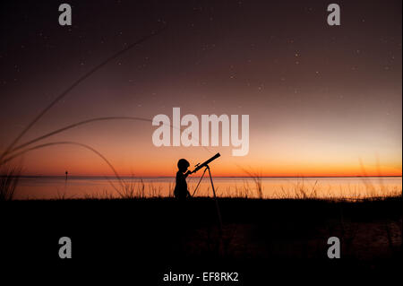 Silhouette der junge Blick auf Sterne durch Teleskop Stockfoto