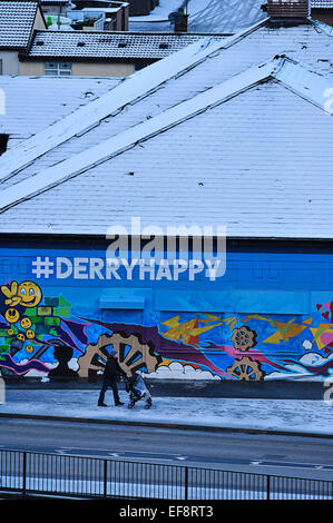 Londonderry, Nordirland. 29. Januar 2015. UK Wetter Schnee in Londonderry ein Mann mit einem Kinderwagen geht es vorbei an einem Wandgemälde in Londonderry (Derry) in Nordirland. Mehr Schnee dürfte für viele Teile von Nordirland und Großbritannien Morgen Kredit: George Sweeney/Alamy Live News Stockfoto