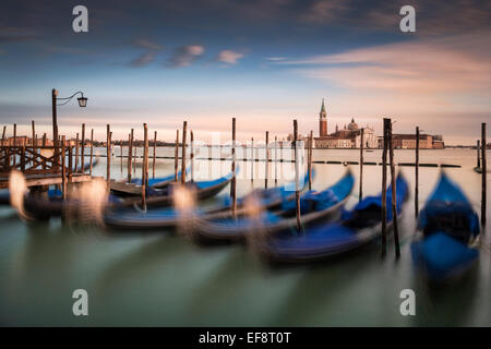 Italien, Venedig, vertäute Gondeln hintereinander mit Skyline der Stadt im Abstand Stockfoto