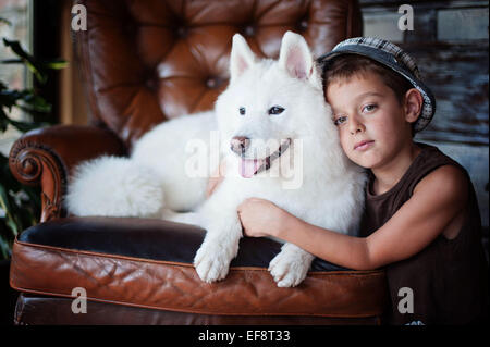 Porträt eines jungen (8-9) mit Samojeden Hund Stockfoto