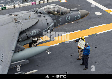 Ein US-Seemann leitet ein Kampfflugzeug der US Marine Corps AV-8 b Harrier II Take off aus dem Flugdeck auf amphibischer Angriff Schiff USS Bonhomme Richard 28. Januar 2015 in das Ostchinesische Meer zur Vorbereitung auf. Stockfoto