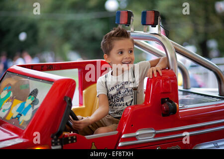 Junge (4-5) Steuerwagen im Vergnügungspark Stockfoto