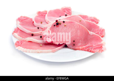 eine Platte mit einigen Scheiben von rohem Schweinefleisch Lende auf weißem Hintergrund Stockfoto