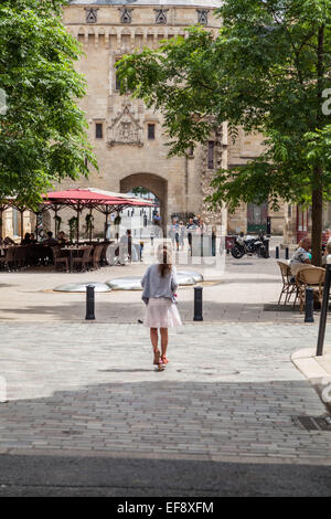 Ein kleines Mädchen auf einem Roller fährt in Richtung Calihau Tor, historische Architektur in Bordeaux Frankreich. Stockfoto