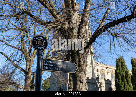 Metall Schild auf der Burg, Museum und Marktplatz in Oakham, Rutland, mit dem 14. Jahrhundert Kirche Allerheiligen. Stockfoto