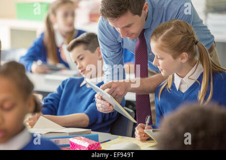 Lehrer mit seinen Schülern im Klassenzimmer mit TabletPC Stockfoto