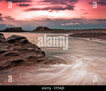 Schöne, rosa, Sonnenuntergang über dem Meer bei Bude in Cornwall. Stockfoto