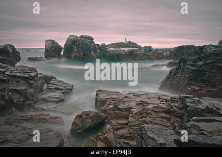 Nebel deckt die eisigen blauen Gewässern der Godrevy. Der Leuchtturm schürt in den Hintergrund. Stockfoto