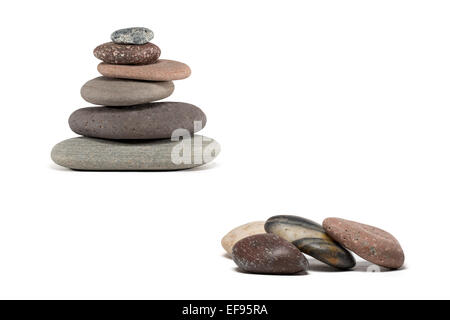 Stein-Cairn aus einer Vielzahl von bunten Lake Superior Felsen gemacht.  Vier zusätzliche Steinen im Vordergrund. Isoliert auf weiss. Stockfoto