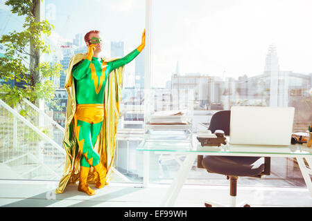 Superheld reden über Handy im Büro Stockfoto