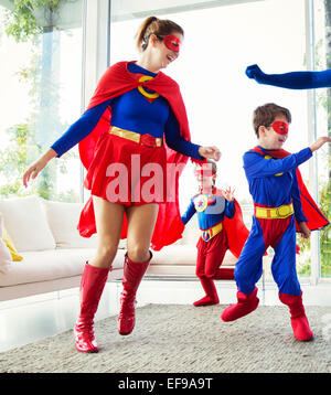 Familie von Superhelden spielen im Wohnzimmer Stockfoto