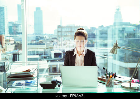 Geschäftsfrau, die Arbeiten am Laptop im Büro Stockfoto