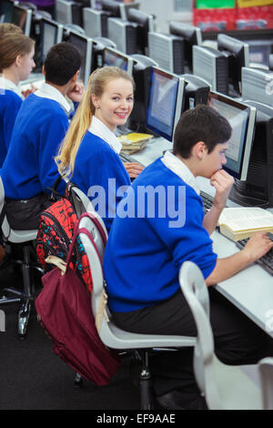 Studenten, lächelnd, sitzen und lernen im Computerraum Stockfoto