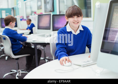 Porträt der Grundschule Mädchen tragen blaue Schuluniform mit computer Stockfoto