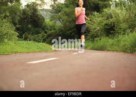 junge Fitness Frau Läufer laufen auf Waldweg Stockfoto