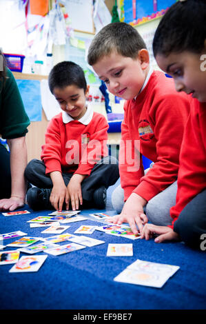 Lehrer spielen Snap mit Kindern in der Grundschule in London Stockfoto