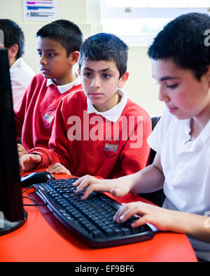 Kinder im Grundschulalter in der Grundschule in London lernen, code und Programmierung auf Computern zu tun Stockfoto