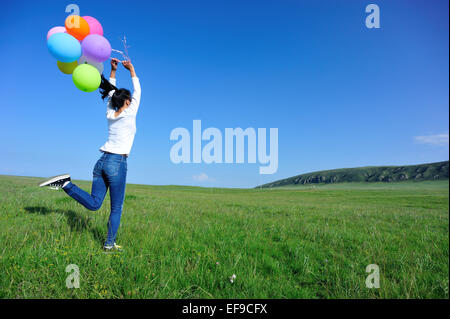 eine junge Asiatin mit bunten Luftballons Stockfoto