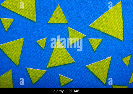 gelber Stoff Dreiecke auf blauen strukturiertem material Stockfoto