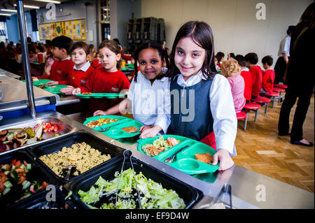 Mittagessen in der UK State Primary School Kinder, die an der Inner City London Primary School ein Schulessen erhalten Stockfoto