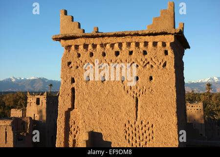 Türme der Kasbah Amerhidil in Skoura Oase mit einer Ansicht des hohen Atlas-Gebirge bedeckt in Schnee, Marokko Stockfoto