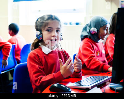 Mädchen in der Grundschule eine Online-Mathe-Klausur zu tun und mit ihren Fingern zählen Stockfoto