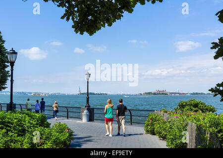 Esplanade in Battery Park City mit Ellis Island und der Freiheitsstatue in Ferne, senken Sie Manhattan, NYC, New York City, NY, USA Stockfoto