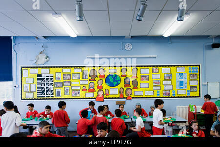 Zur Mittagszeit am UK staatliche Grundschullehrer und Kinder im Grundschulalter in der Grundschule Stockfoto