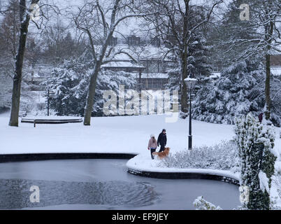 2 Personen, Spaziergang mit dem Hund im Schnee, Pavilion Gardens, Buxton Stockfoto