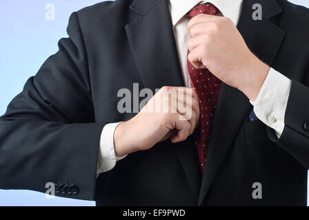 Junger Geschäftsmann im Anzug anpassen seine Krawatte Stockfoto