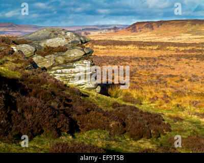 Felsformationen im Winter am Curbar Rand im Peak District Nationalpark Derbyshire England UK mit stürmischen Himmel Stockfoto