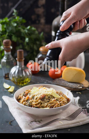 Hinzufügen von Papier zu Spaghetti mit Tomatensauce und Kräutern Stockfoto