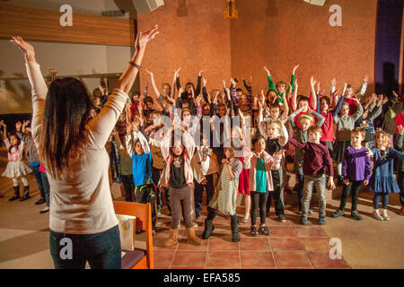 Gemischtrassig Kleinkinder Geste wie sie Weihnachtslieder St. Timothy katholische Kirche, Laguna Niguel, CA. Hinweis Chorleiter im Vordergrund üben. Stockfoto