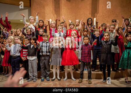 Gemischtrassig Kleinkinder Geste wie sie Weihnachtslieder während der Christmette am St. Timothy katholische Kirche, Laguna Niguel, CA. Hinweis Chorleiter Hand im Vordergrund links singen. Stockfoto