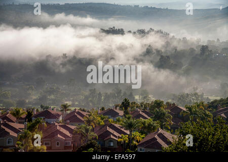 Am frühen Morgensonne zerstreut Meer Nebel um Wohnhäuser im Krone-Tal in küstennahen Laguna Niguel, CA. Stockfoto