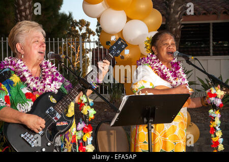 Dekoriert mit Luftballons und Kunstblumen, führen zwei hawaiische Musiker bei einem Hula-Festival in den Ruhestandsgemeinschaft von Laguna Woods, CA. beachten Sie native Hawaiian Frau auf der rechten Seite. Stockfoto