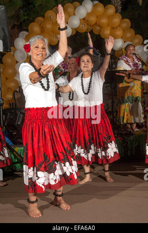 Kostümierte ältere Frauen an der Laguna Woods, CA, Ruhestandsgemeinschaft tanzen Hula auf einem hawaiianischen Thema Festival. Beachten Sie die hawaiische Musiker im Hintergrund. Stockfoto