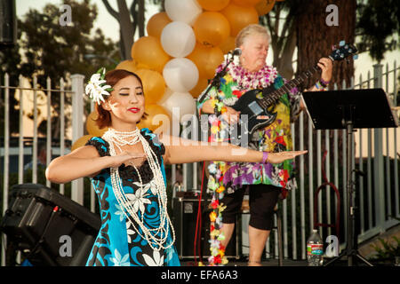 Eine native Hawaiian Tänzerin führt den Hula bei einem Ruhestand Gemeinschaft Festival in Laguna Woods, ca. Note Musiker im Hintergrund. Stockfoto
