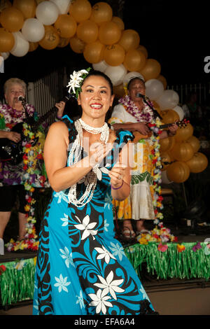 Eine native Hawaiian Tänzerin führt den Hula bei einem Ruhestand Gemeinschaft Festival in Laguna Woods, CA. Hinweis hawaiische Musiker im Hintergrund. Stockfoto