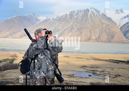 Jäger suchen Wildtiere wie Rothirsch, Damwild, Gemsen oder Himalaya-Tahr in der Südalpen Neuseelands Stockfoto