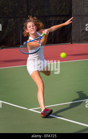 Mit Konzentration und sorgfältige Timing kehrt ein junge Frau Tennisspieler eine dienen in San Juan Capistrano, Kalifornien. Stockfoto