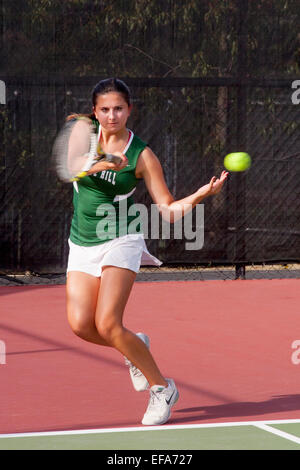 Mit Konzentration und sorgfältige Timing kehrt ein junge Frau Tennisspieler eine dienen in San Juan Capistrano, Kalifornien. Stockfoto