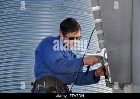 Ein Klempner anbringen, Dachrinnen, ein Geschäftshaus Stockfoto