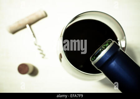 Rotwein in einem Glas aus der Flasche gegossen Stockfoto