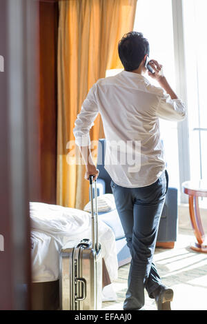 Jungunternehmer am Telefon im Hotelzimmer Stockfoto